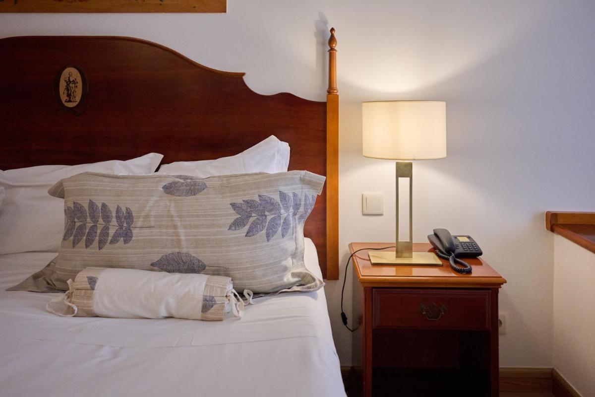 Uma cama ou camas num quarto em Quintinha Sao Joao Hotel & Spa