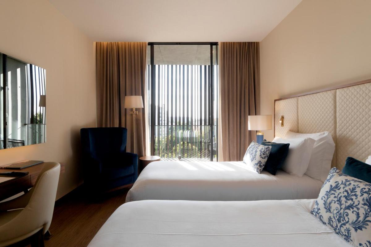 Uma cama ou camas num quarto em Boeira Garden Hotel Porto Gaia, Curio Collection by Hilton