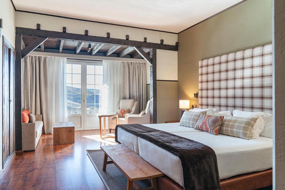 Un dormitorio con una cama grande con cabecero de madera. en Vincci Selección Rumaykiyya, en Sierra Nevada 56 fotos más