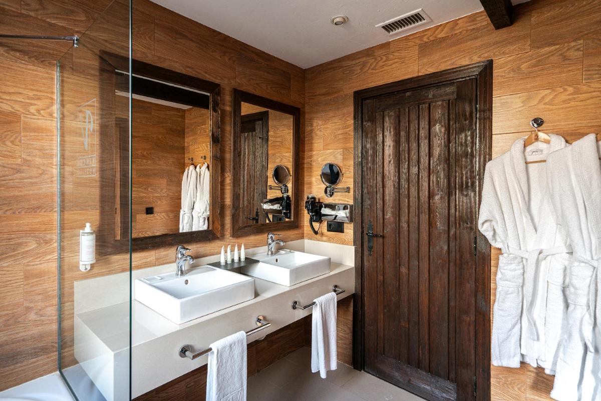 baño con 2 lavabos y puerta de cristal en Vincci Selección Rumaykiyya, en Sierra Nevada