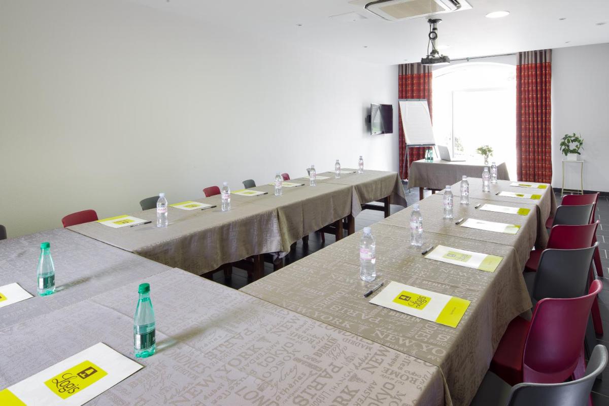 une rangée de tables dans une pièce avec des chaises dans l'établissement Hotel Blanc, à Marigny-Saint-Marcel 66 autres photos