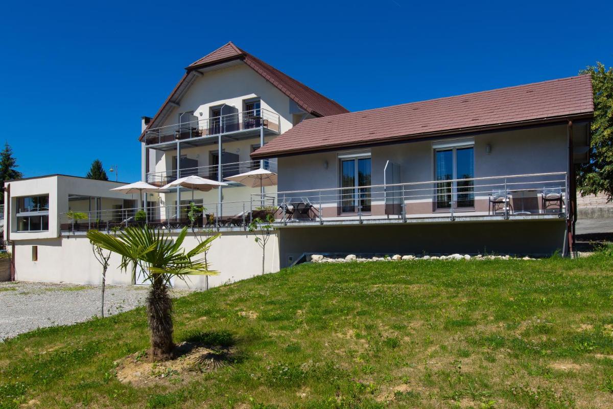 une maison avec un palmier devant dans l'établissement Hotel Blanc, à Marigny-Saint-Marcel