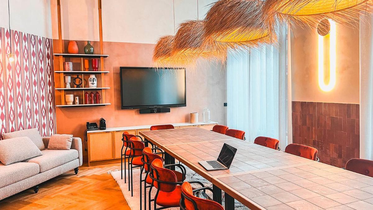 Cette chambre dispose d'une table, d'un canapé et d'une télévision. dans l'établissement Bloom House Hôtel & SPA, à Paris