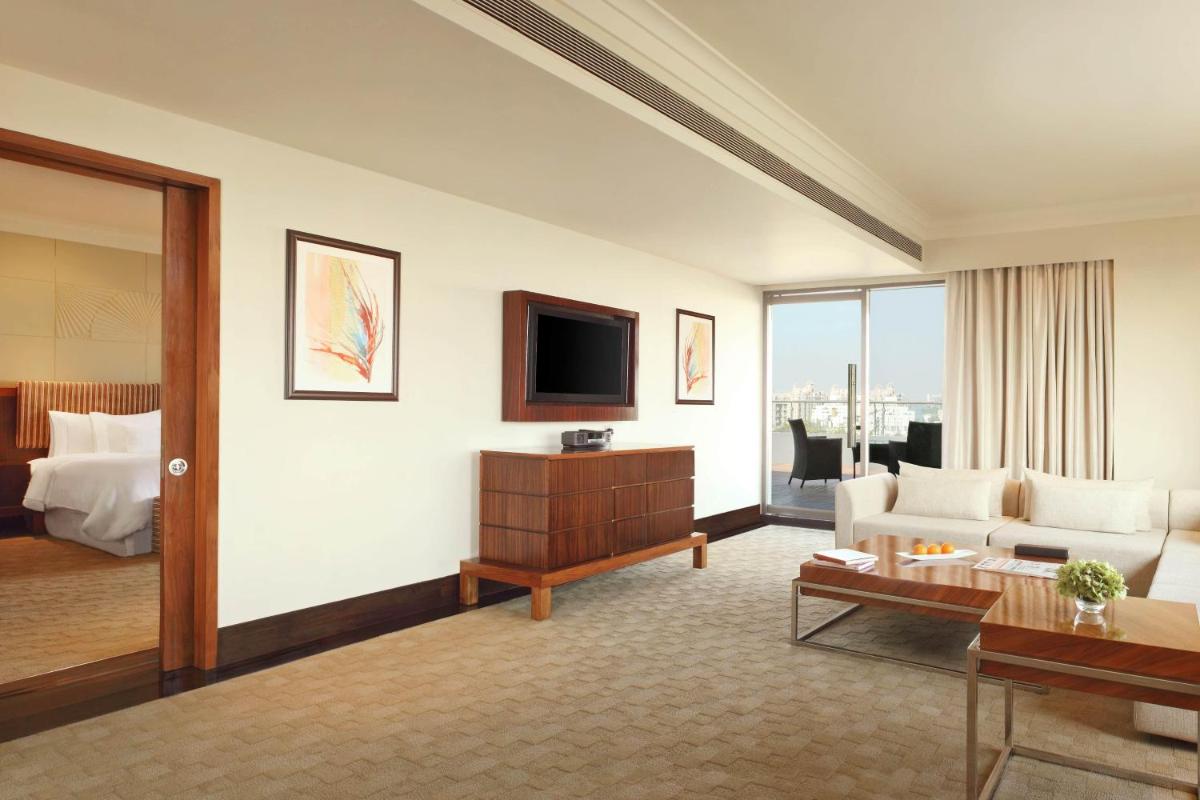 a living room with a couch and a tv at The Westin Pune Koregaon Park in Pune