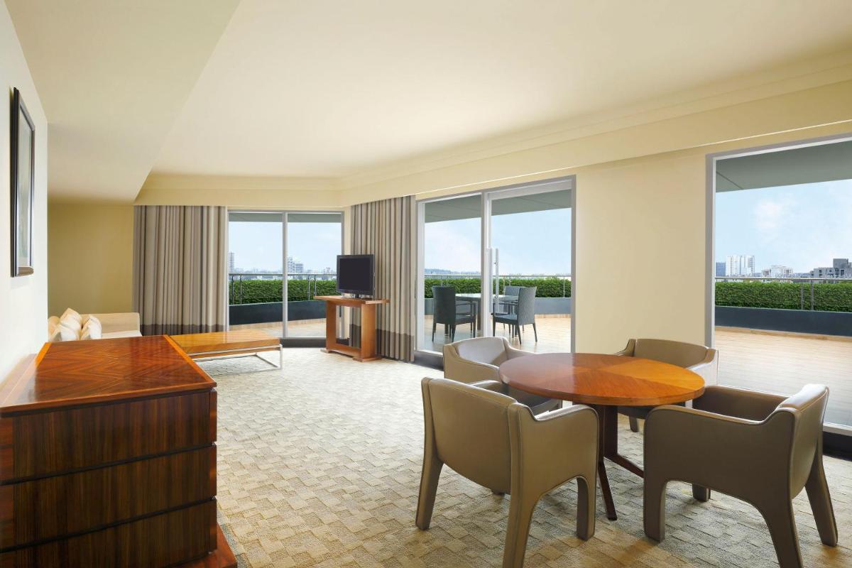 a hotel room with a table and chairs and a living room at The Westin Pune Koregaon Park in Pune