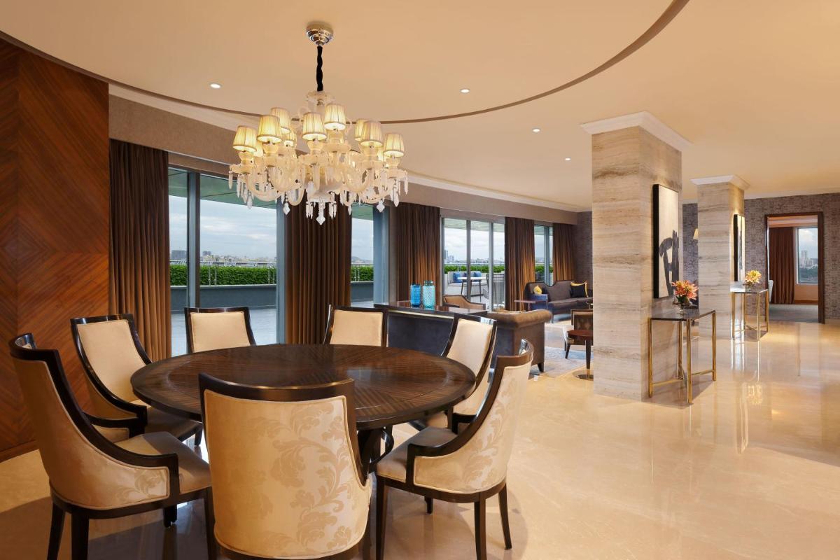 a dining room with a table and a chandelier at The Westin Pune Koregaon Park in Pune