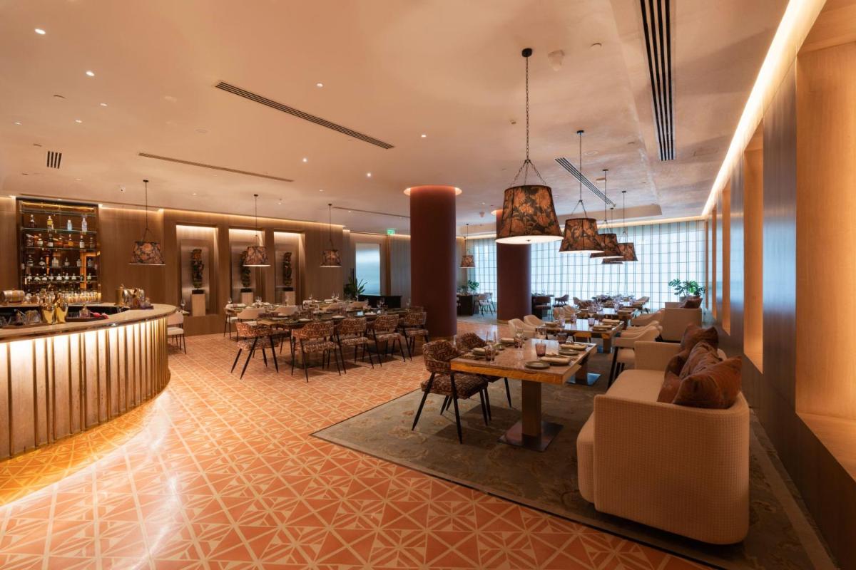 a restaurant with tables and chairs and a bar at The Westin Pune Koregaon Park in Pune