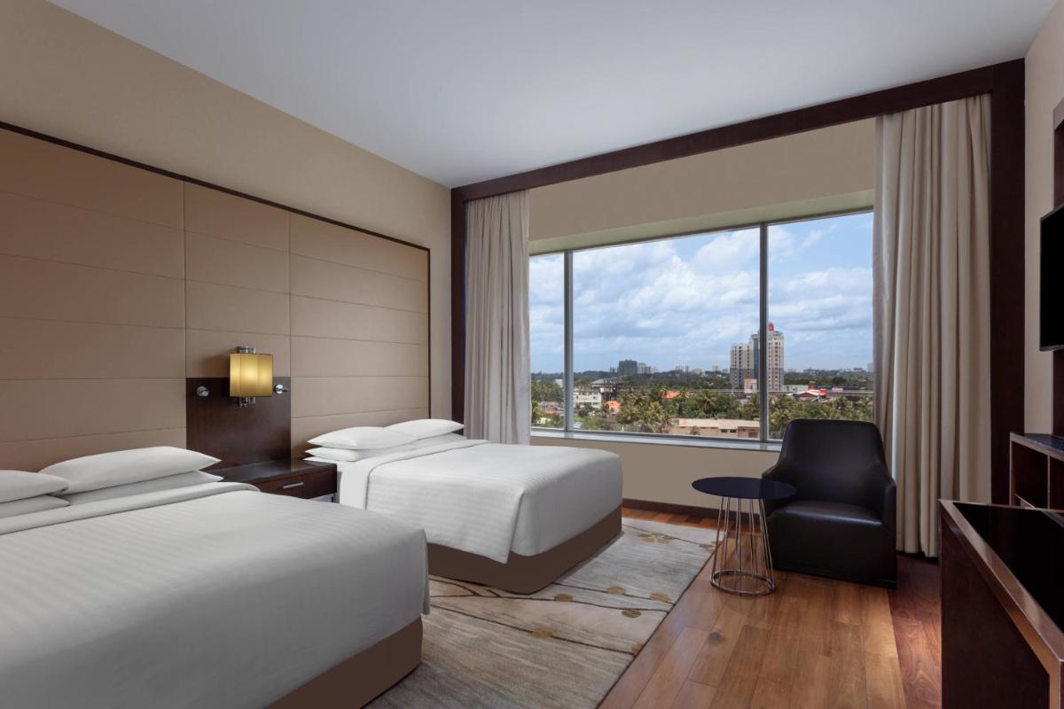 a hotel room with two beds and a window at Kochi Marriott Hotel in Cochin