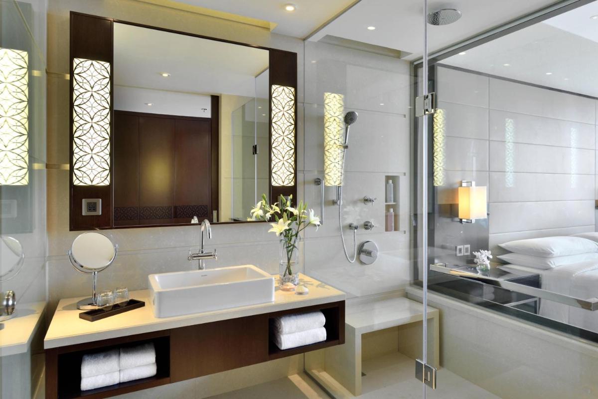 a bathroom with a sink and a mirror at Kochi Marriott Hotel in Cochin