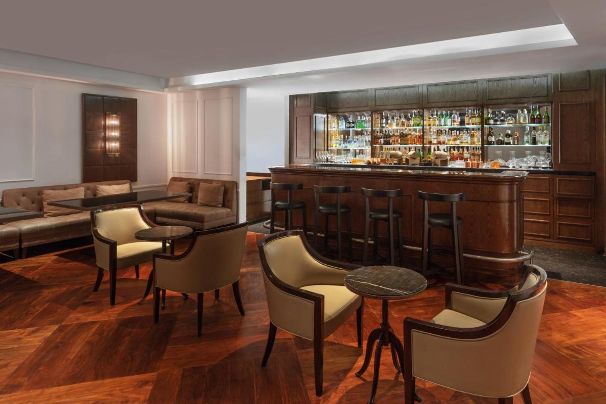 a bar in a hotel room with chairs and a couch at Kochi Marriott Hotel in Cochin