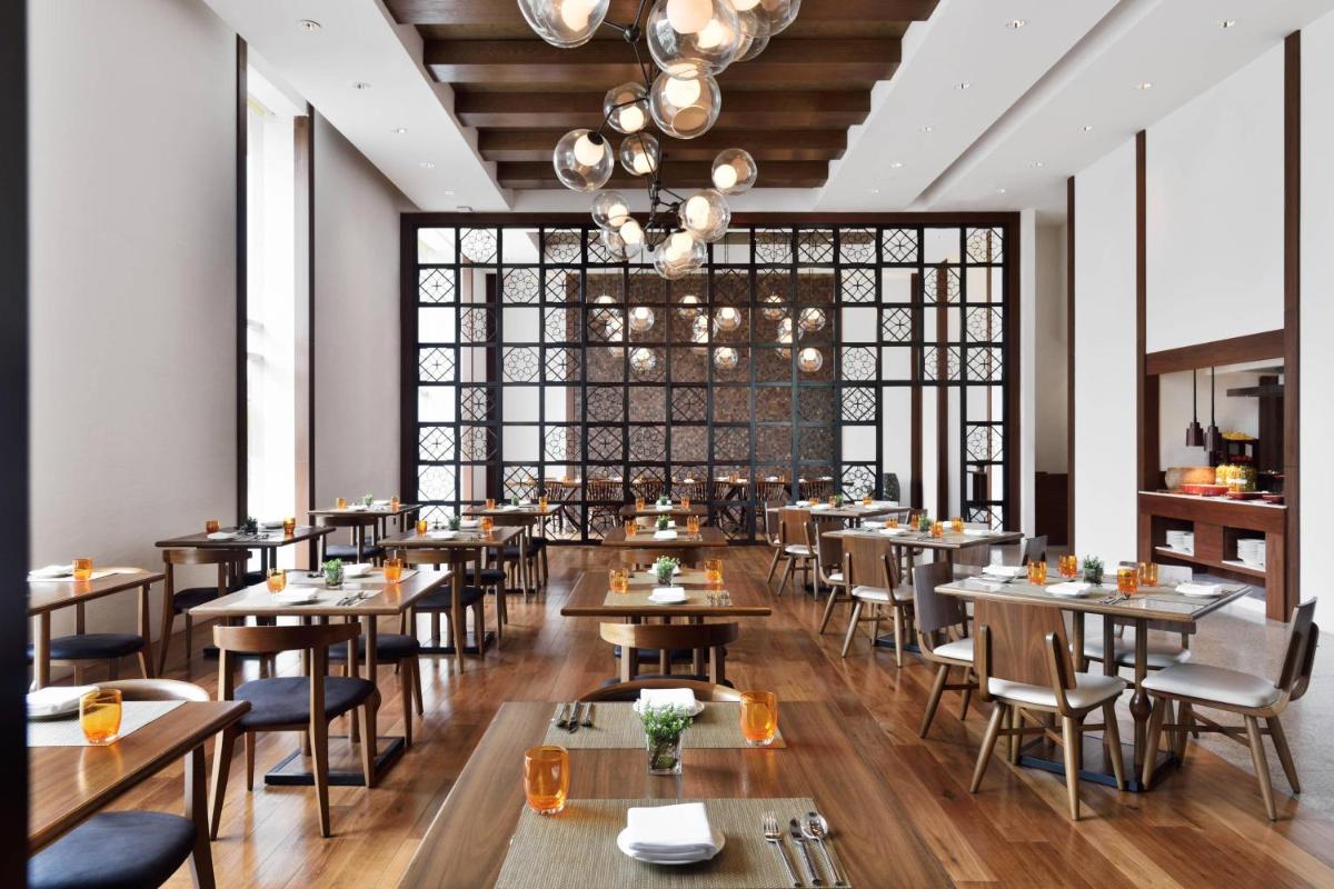 a restaurant with tables and chairs and a large window at Kochi Marriott Hotel in Cochin