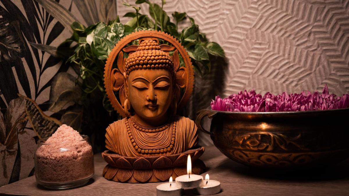 a statue of a goddess sitting next to a bowl of flowers at Holiday Inn New Delhi Aerocity by IHG in New Delhi