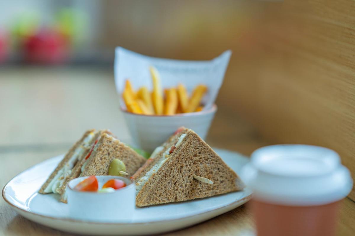 a plate of food with a sandwich and a cup of fries at Hyderabad Marriott Hotel & Convention Centre in Hyderabad