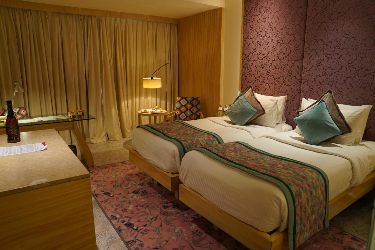a hotel room with a bed and a desk at Hotel Royal Orchid Jaipur, Tonk Road in Jaipur