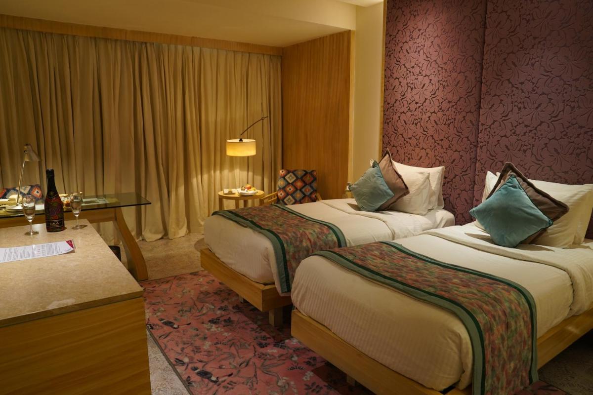 a hotel room with two beds and a desk at Hotel Royal Orchid Jaipur, Tonk Road in Jaipur