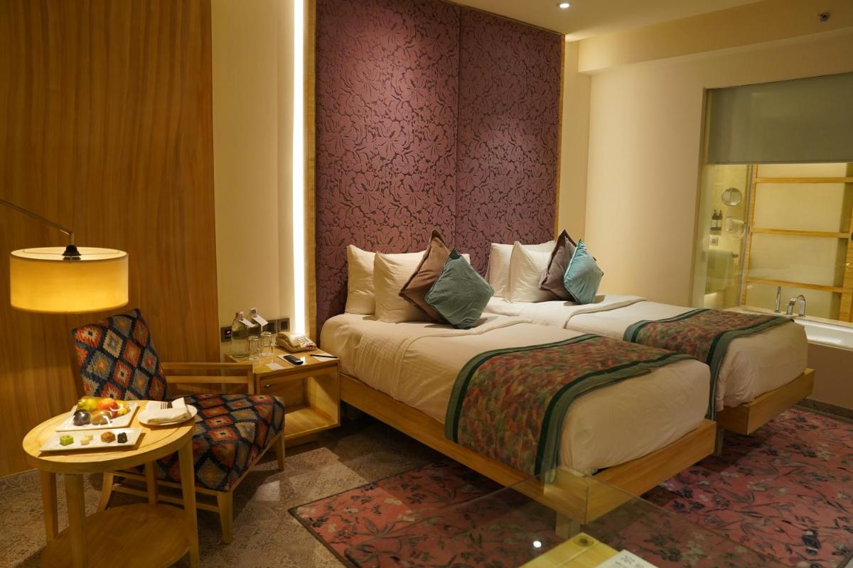 a hotel room with two beds and a table at Hotel Royal Orchid Jaipur, Tonk Road in Jaipur