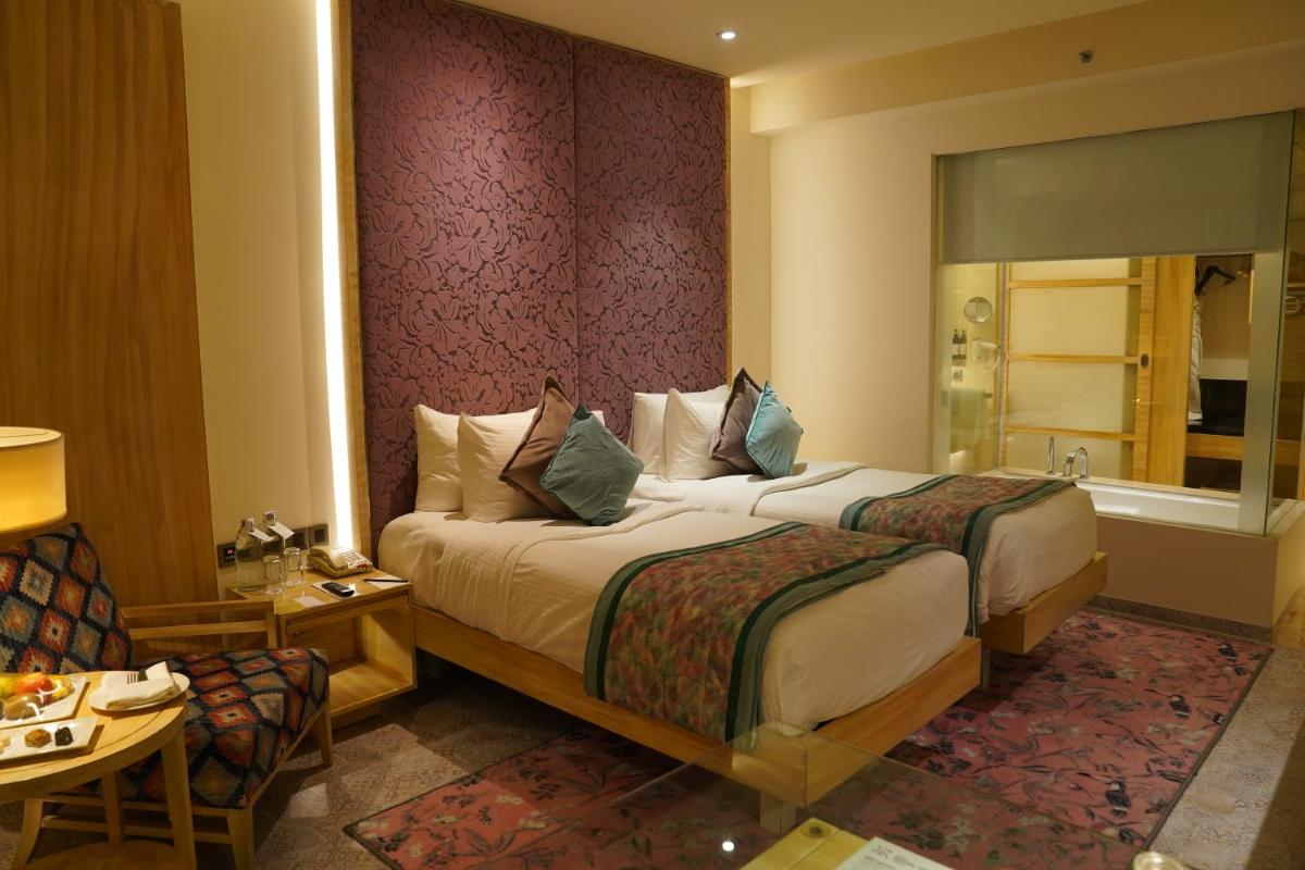 a hotel room with two beds and a bathroom at Hotel Royal Orchid Jaipur, Tonk Road in Jaipur