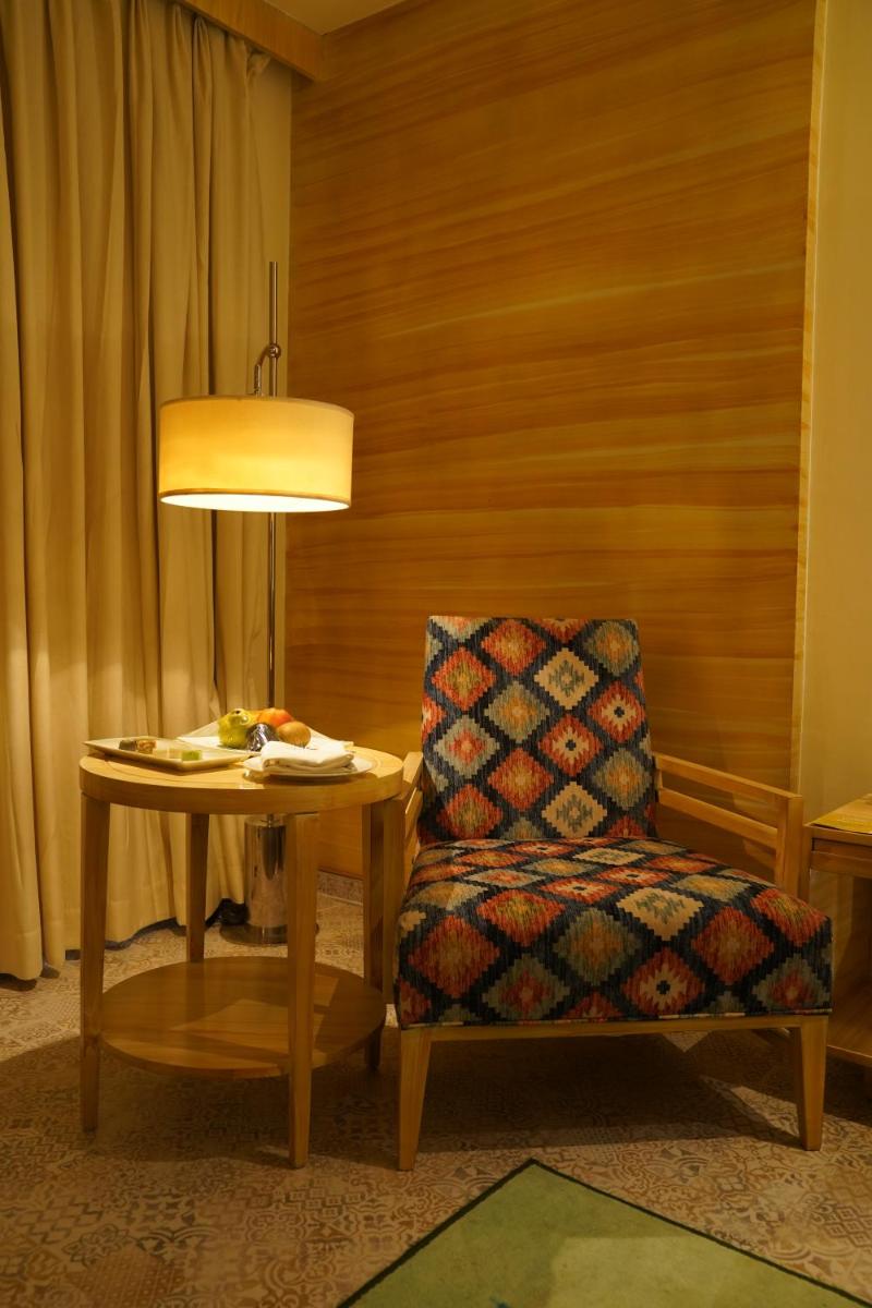a room with a chair and a table and a lamp at Hotel Royal Orchid Jaipur, Tonk Road in Jaipur