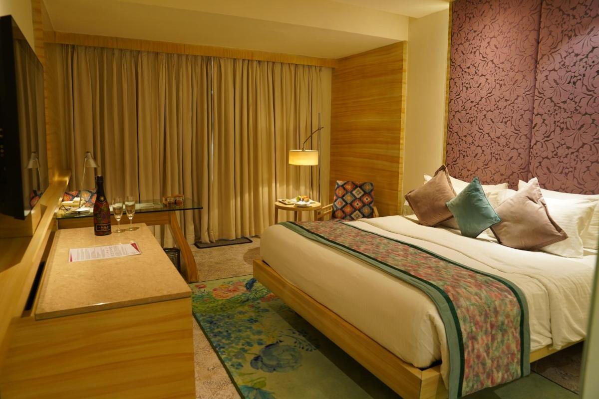 a hotel room with a bed and a desk at Hotel Royal Orchid Jaipur, Tonk Road in Jaipur