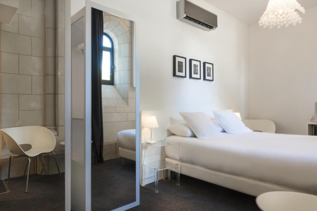 une chambre blanche avec un lit et un miroir dans l'établissement SOZO Hotel, à Nantes