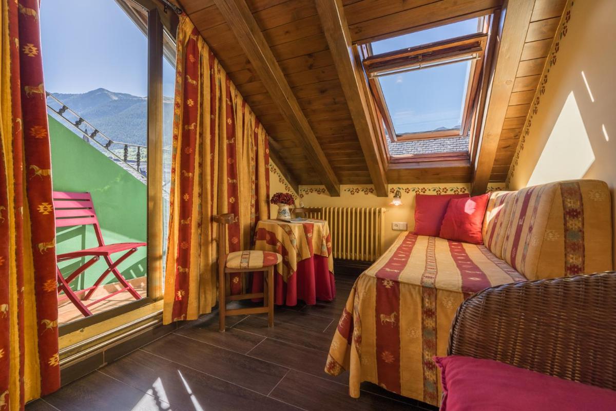 Una pequeña habitación con una cama y una ventana. en Hotel Aran La Abuela, en Vielha