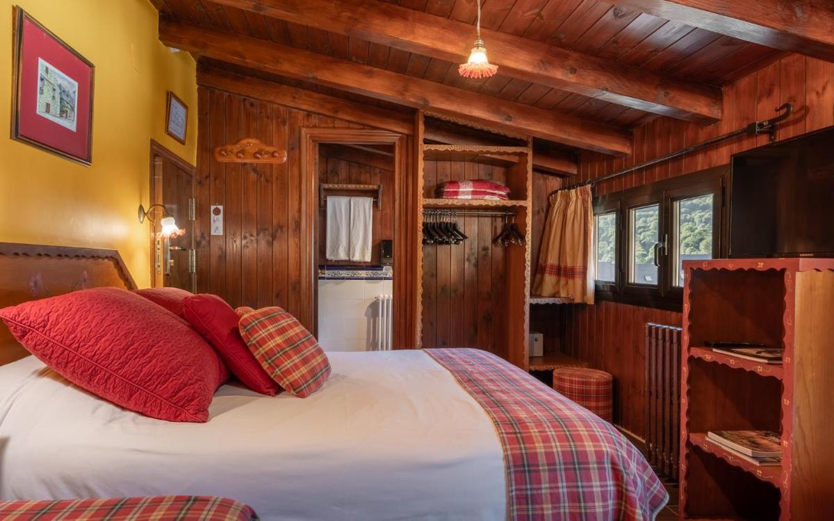 Un dormitorio con una cama con almohadas rojas. en Hotel Aran La Abuela, en Vielha 115 fotos más