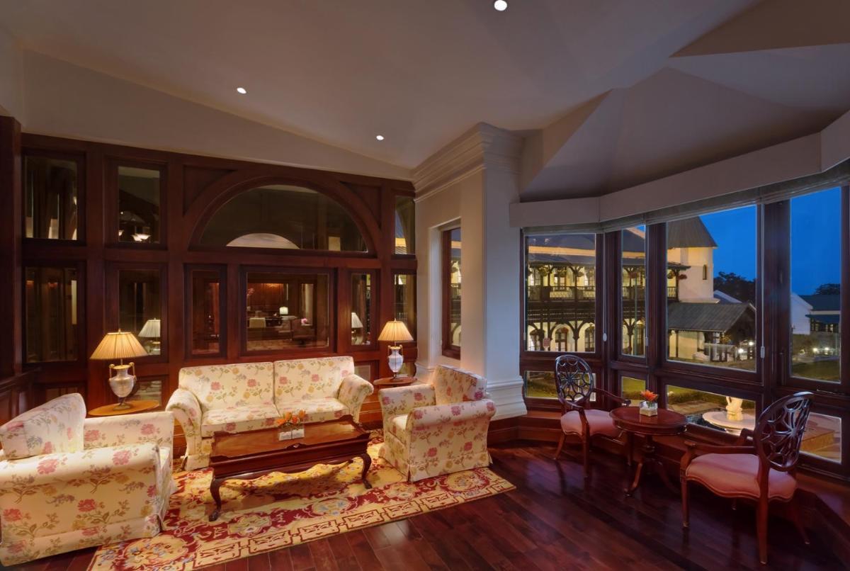 a living room with a couch and chairs and windows at Welcomhotel by ITC Hotels, The Savoy, Mussoorie in Mussoorie