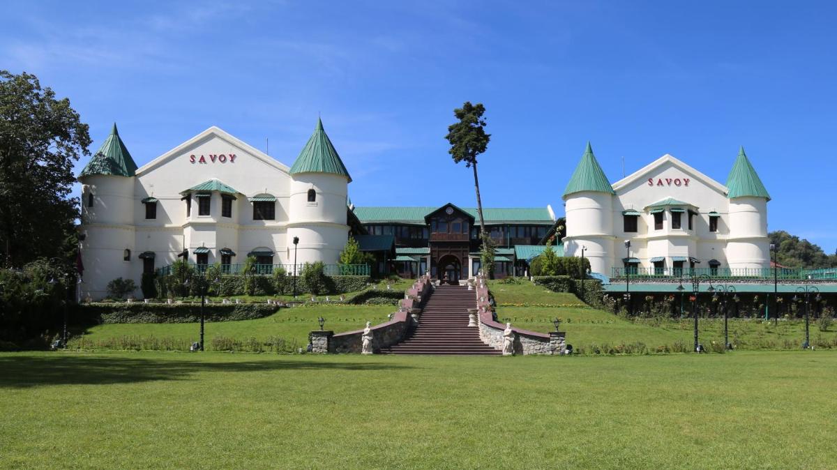 a large white building with a staircase in front of it at Welcomhotel by ITC Hotels, The Savoy, Mussoorie in Mussoorie