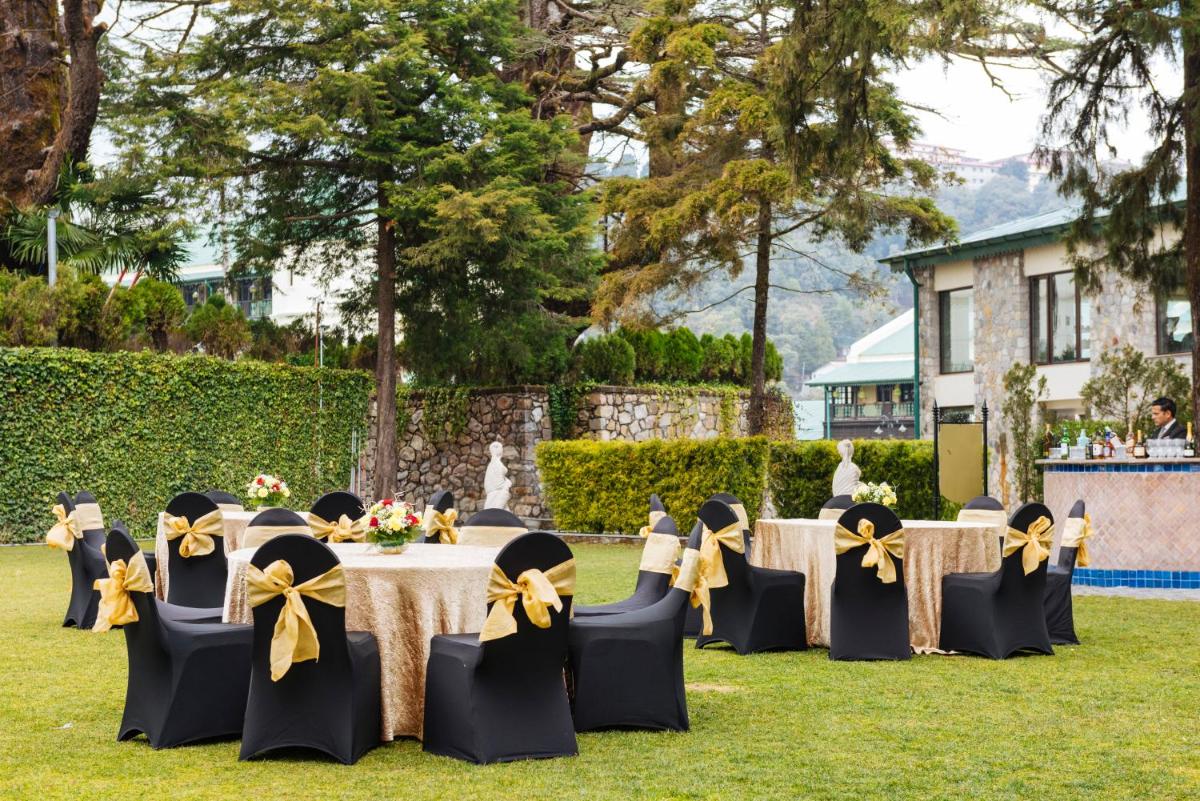 a group of people sitting at a table with yellow bows at Welcomhotel by ITC Hotels, The Savoy, Mussoorie in Mussoorie