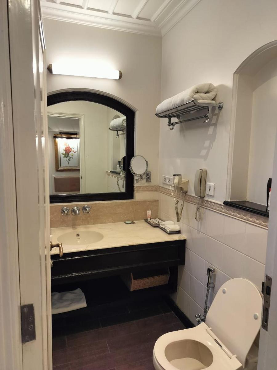 a bathroom with a sink and a toilet and a mirror at Welcomhotel by ITC Hotels, The Savoy, Mussoorie in Mussoorie