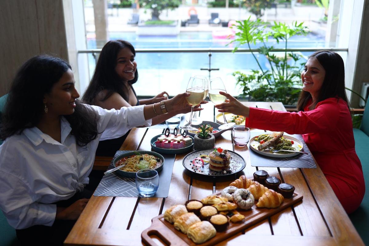 a group of women sitting around a table with food at Novotel Hyderabad Airport in Hyderabad