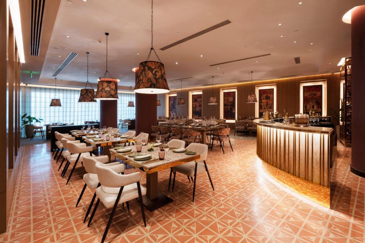 a restaurant with tables and chairs and a bar at The Westin Pune Koregaon Park in Pune