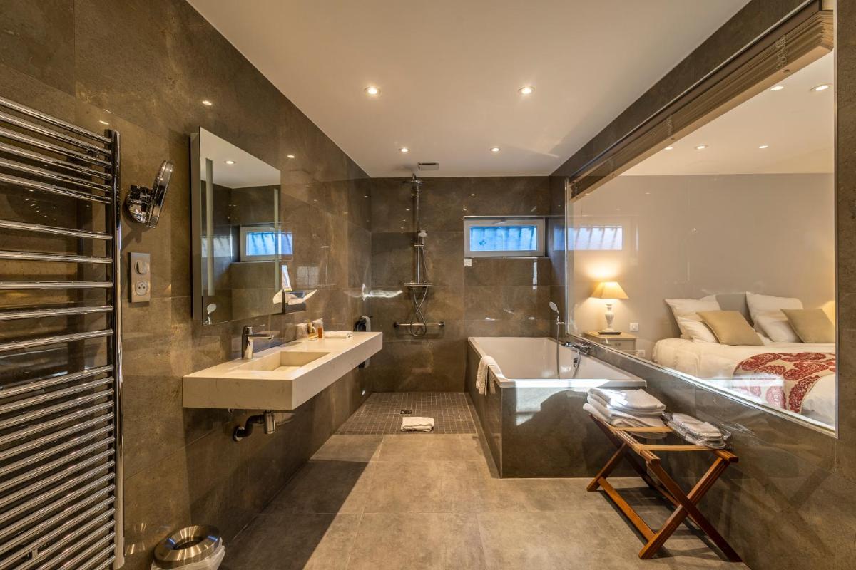 une salle de bain avec un lavabo, un lit et une baignoire dans l'établissement Les Jardins d'Epicure, à Bray-et-Lû 93 autres photos