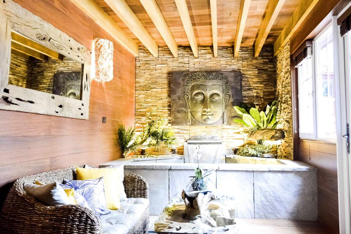 une chambre avec un canapé et une statue sur un mur dans l'établissement Les Jardins d'Epicure, à Bray-et-Lû