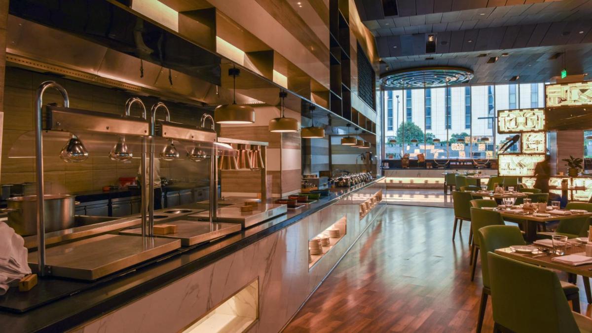 a restaurant with a bar with tables and chairs at Holiday Inn New Delhi Aerocity by IHG in New Delhi