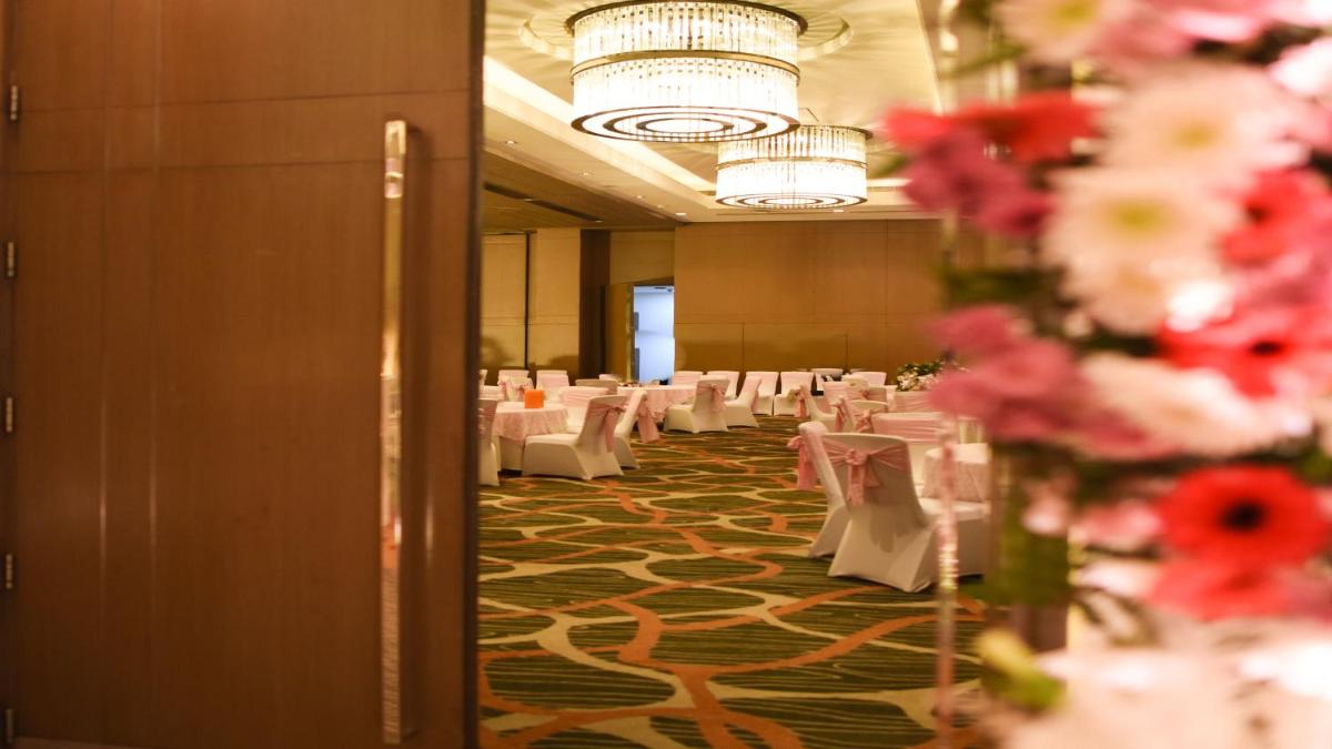 a banquet hall with white tables and pink flowers at Holiday Inn New Delhi Aerocity by IHG in New Delhi