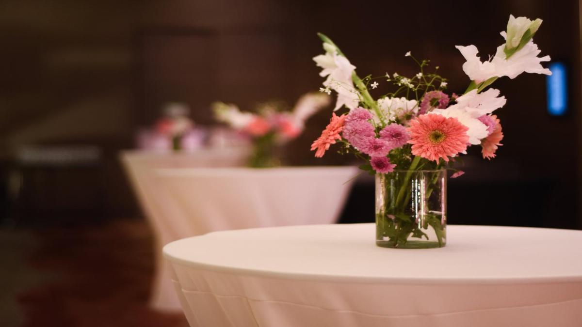 a vase of flowers sitting on top of a table at Holiday Inn New Delhi Aerocity by IHG in New Delhi