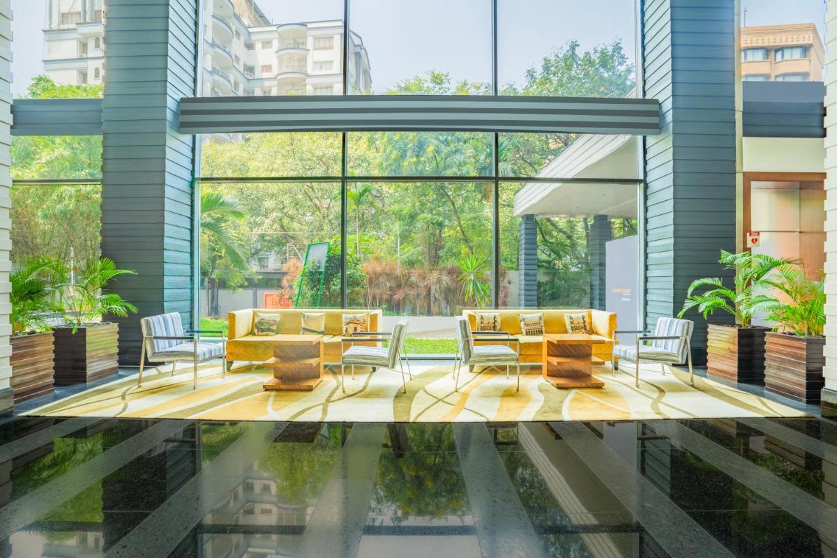 a lobby with a table and chairs and a pool at Courtyard by Marriott Hyderabad in Hyderabad