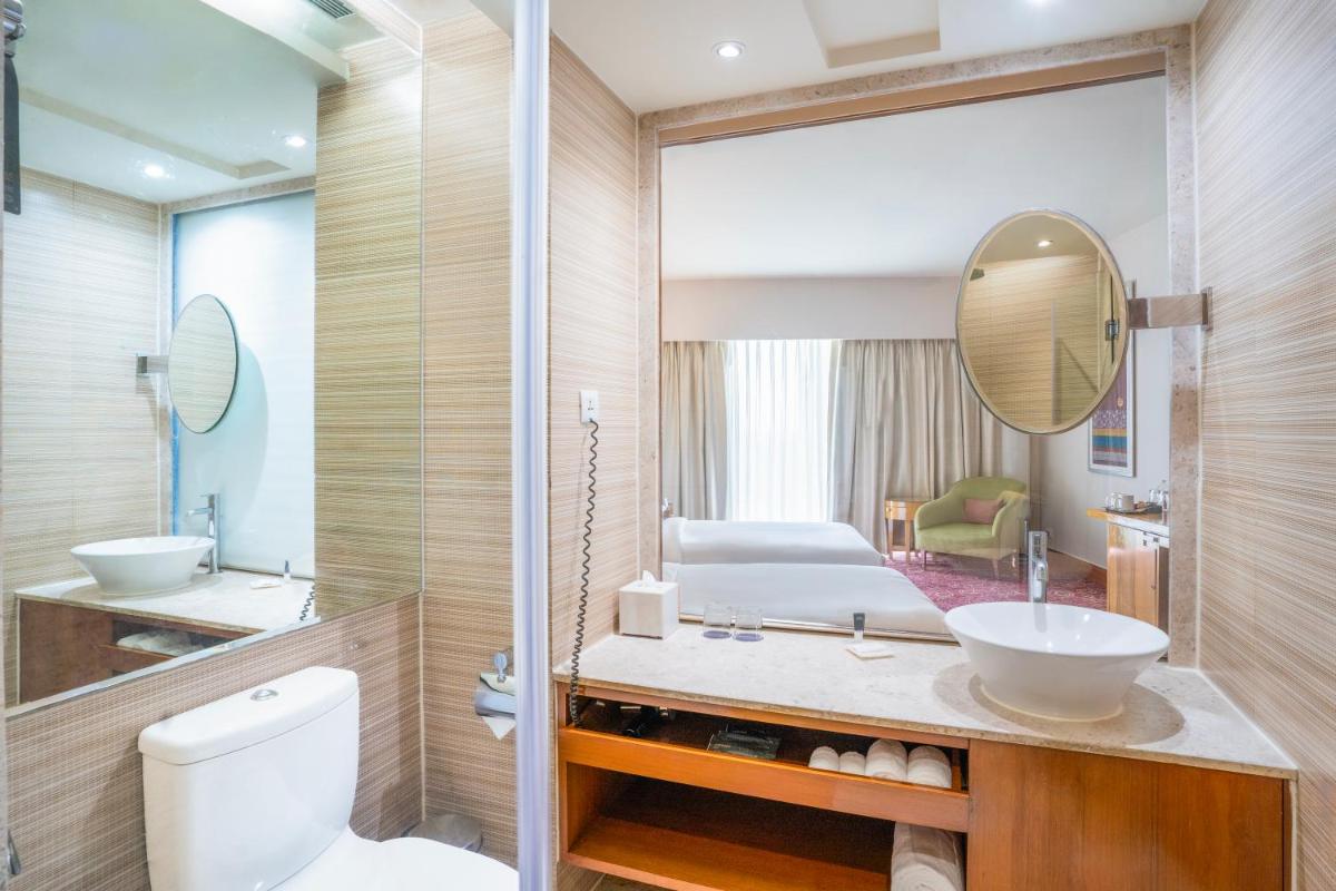 a bathroom with a toilet and a sink and a mirror at Courtyard by Marriott Hyderabad in Hyderabad