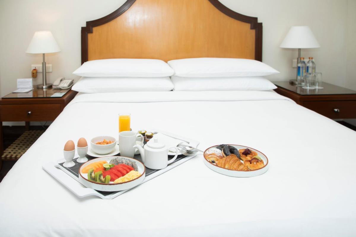 a breakfast tray on a bed with food on it at Courtyard by Marriott Hyderabad in Hyderabad