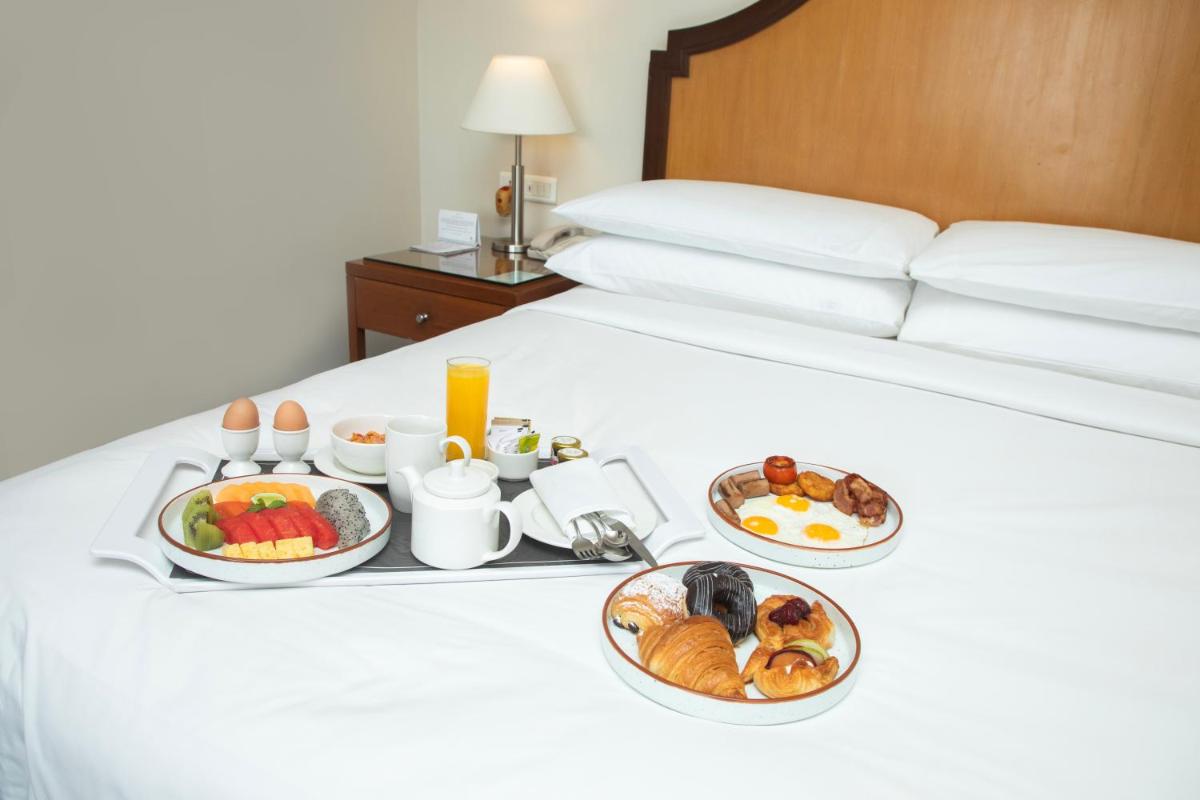 a tray of breakfast foods on a bed at Hyderabad Marriott Hotel & Convention Centre in Hyderabad