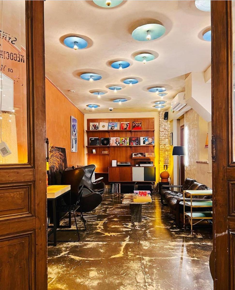 un salon avec des canapés et des fauteuils et un plafond avec des lumières dans l'établissement Hôtel La Nouvelle République & Hammam, à Paris