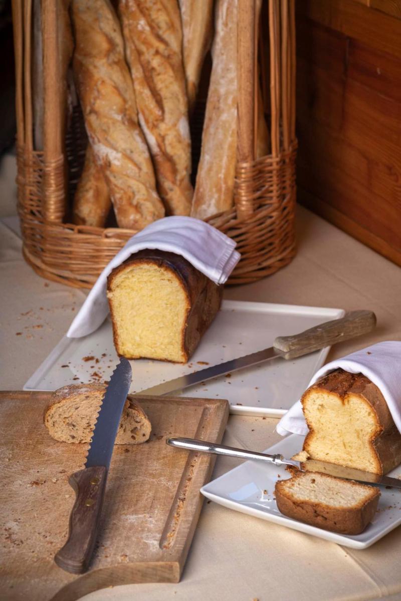 une tranche de pain sur une planche à découper avec un panier dans l'établissement Logis Hôtel Les Peupliers, à Baratier 58 autres photos