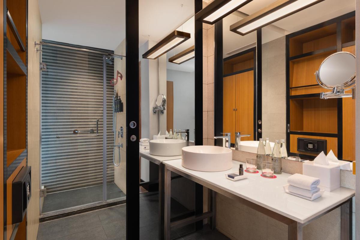 a bathroom with two sinks and a shower at Aloft Bengaluru Outer Ring Road in Bengaluru