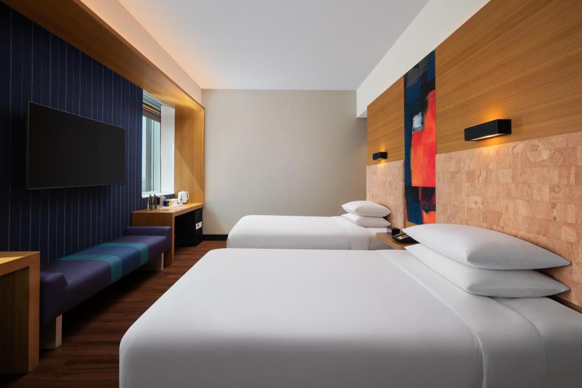 a hotel room with two beds and a tv at Aloft Bengaluru Outer Ring Road in Bengaluru