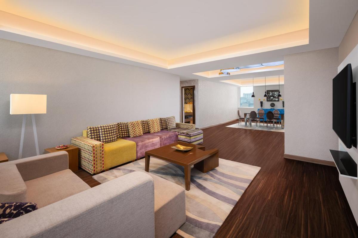 a living room with a couch and a tv at Aloft Bengaluru Outer Ring Road in Bengaluru