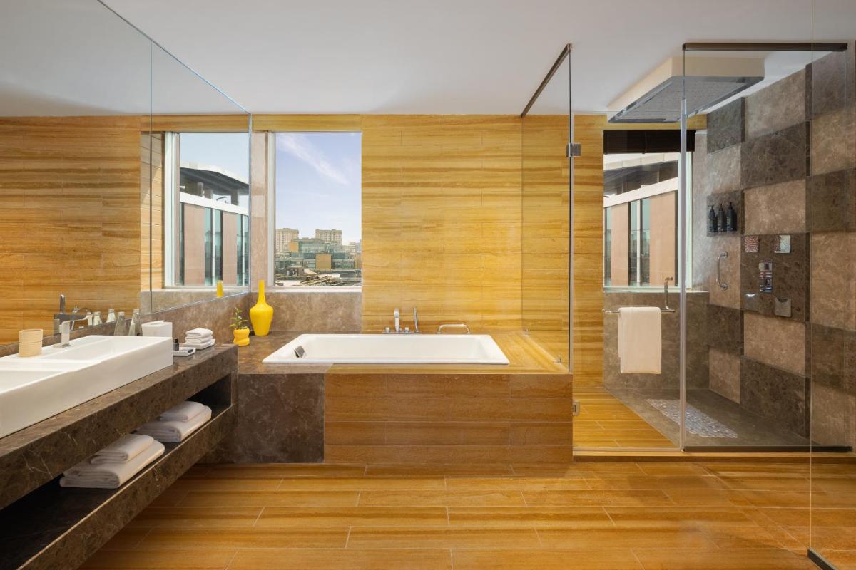 a bathroom with a tub and a sink and a shower at Aloft Bengaluru Outer Ring Road in Bengaluru