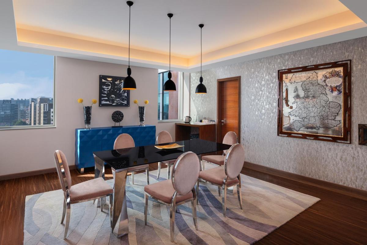 a dining room with a table and chairs at Aloft Bengaluru Outer Ring Road in Bengaluru