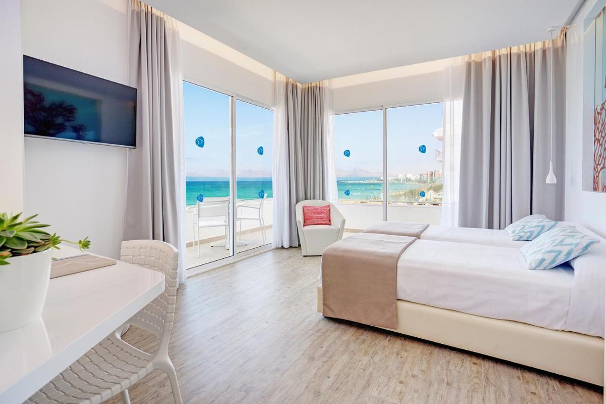 Un dormitorio con una cama y un balcón con vista al mar. en The Sea Hotel by Grupotel - Adults Only, en Can Picafort