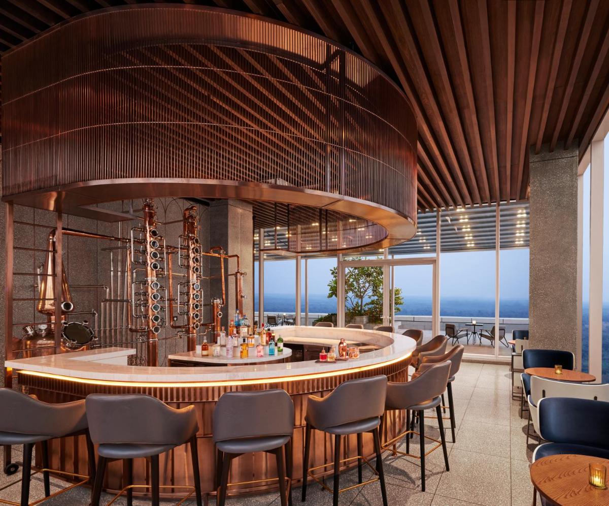 a restaurant with chairs and a bar with a view at Taj The Trees, Mumbai in Mumbai